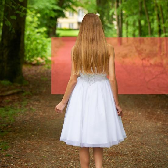 Pige på sti i konfirmationskjole.