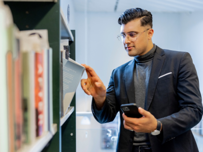 Mand der afhenter bog og har reserveringsnummer på mobilen