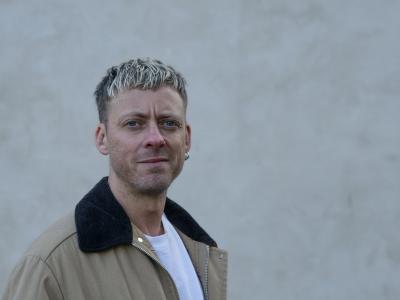 Forfatteren Theis Ørntoft foran en grå mur